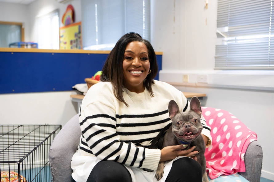 TV presenter sitting on a chair with a French Bulldog in her lap