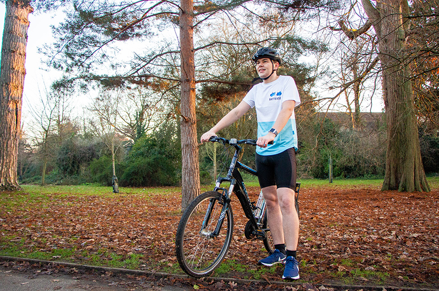 Cyclist on bike in the park wearing Battersea fundraising cycling top