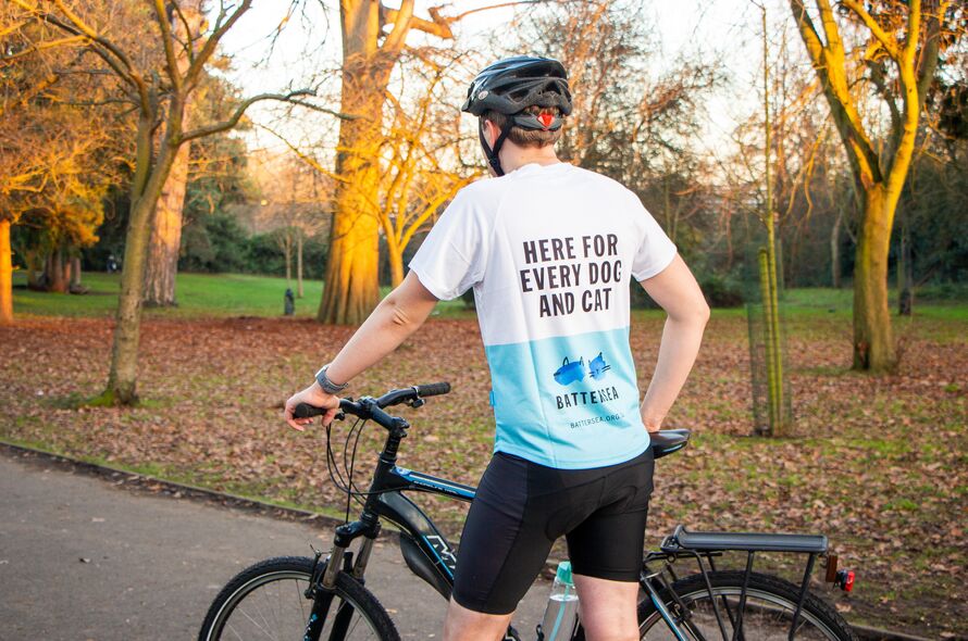 Man in Battersea fundraising top with his bike in the park