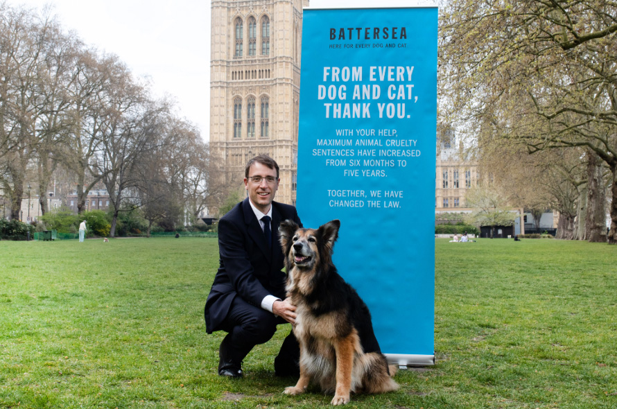 Peter next to dog in front of animal welfare campaigning poster