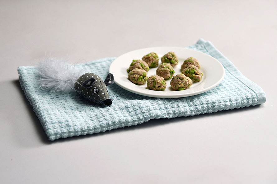 Tuna balls on a plate with a cat toy next 