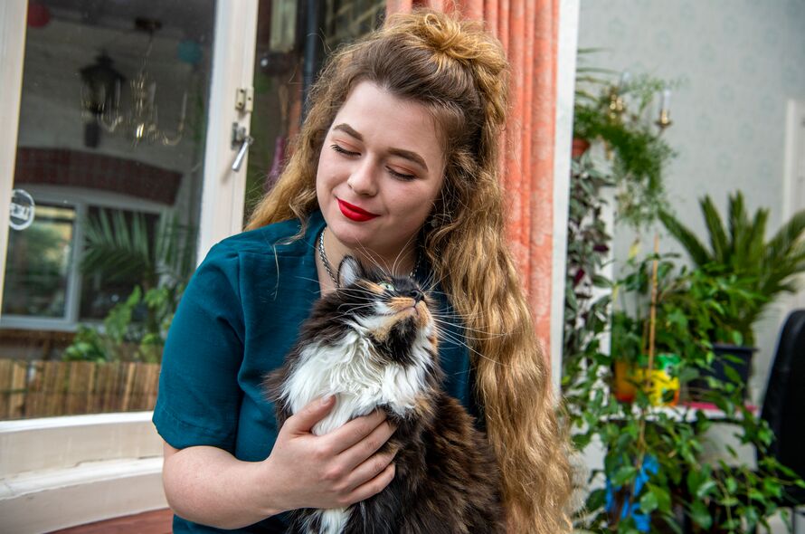 Woman stroking a cat on her lap