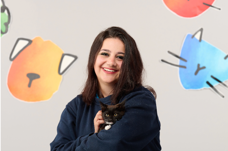 Battersea staff member holding a cat in her arms 