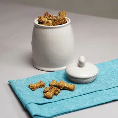 A white ceramic jar filled with homemade dog biscuits
